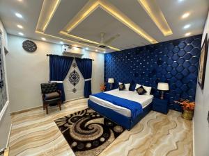 a blue bedroom with a bed and a chair at Luxury Penthouse Bahria Town in Lahore