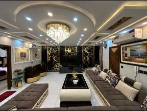 a living room with a couch and a chandelier at Luxury Penthouse Bahria Town in Lahore