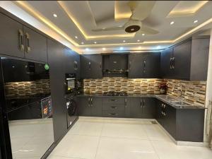 a kitchen with black cabinets and a ceiling at Luxury Penthouse Bahria Town in Lahore