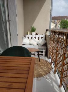 uma varanda com um sofá e uma mesa na varanda em Apt calme, proche hôpital, centre ville em Brive-la-Gaillarde