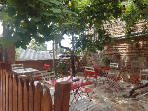 a patio with tables and chairs next to a brick wall at Guest House Tbilisi style in Tbilisi City