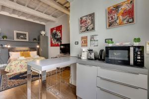 フィレンツェにあるSanto Spirito Studio Flatのキッチン(テーブル、電子レンジ、ベッド付)