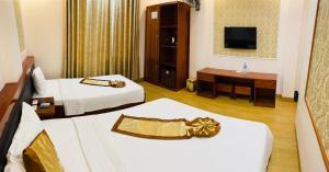 a hotel room with two beds and a television at Victoria hotel in Ha Long