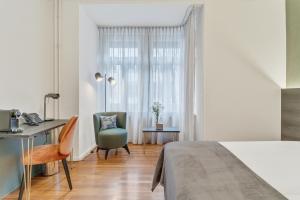 a bedroom with a bed and a desk and a chair at Waldstätterhof Swiss Quality Hotel in Lucerne