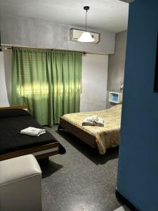 Salvador MaríaにあるHotel El pescadorのベッド2台と緑のカーテンが備わる客室です。 +12枚の写真