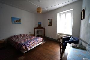 ein Schlafzimmer mit einem Bett und einem Fenster in der Unterkunft La maison du Thoré in Saint-Amans-Valtoret