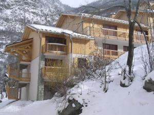 歐黑爾的住宿－Hameau 5 201a - SPA & PISCINE studio 2 pers，一座大木结构建筑,地面上积雪