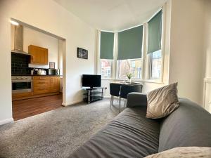 a living room with a couch and a kitchen at Sienna Family Holiday Apartments in Blackpool