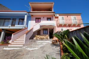 a house with stairs and tables in front of it at Vacanze Mare Teulada in Teulada