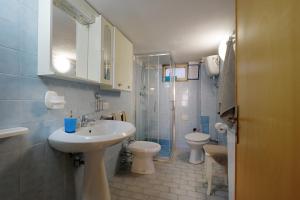 ein Bad mit einem Waschbecken, einem WC und einer Dusche in der Unterkunft Vacanze Mare Teulada in Teulada