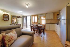 ein Wohnzimmer mit einem Sofa und eine Küche mit einem Tisch in der Unterkunft Vacanze Mare Teulada in Teulada