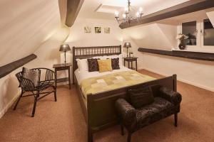een slaapkamer met een groot bed en een stoel bij Cobble Cottage in Whitby