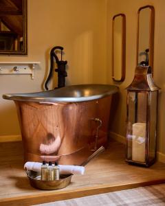 een koperen bad in een kamer met een lantaarn bij The Harcourt Arms in Stanton Harcourt