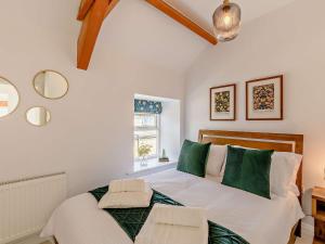 a bedroom with a large bed with green pillows at 4 Bed in North Pennines 92351 in Alston