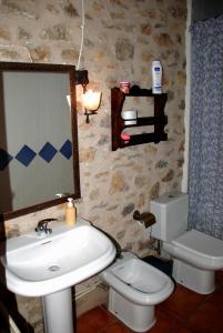uma casa de banho com um lavatório, um WC e um espelho. em Molí d'en Pi em Morella