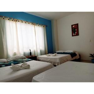 two beds in a room with blue walls at Hotel El Tesoro in Puerto Boyacá