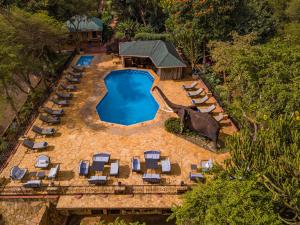 an aerial view of a swimming pool with lounge chairs and a resort at KUDU LODGE & CAMPSITE in Karatu