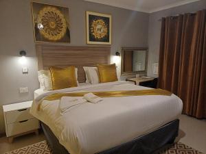 a hotel room with a large bed with yellow pillows at Etang Hotels in Nata