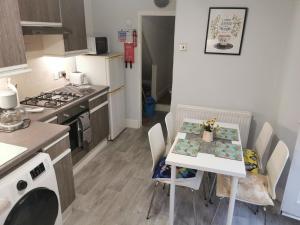 a kitchen with a table with chairs and a stove at 1-Bed victorian gf Apartment in London in London