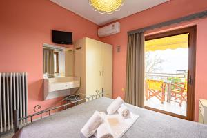 een slaapkamer met een bed en een balkon bij Iliahtida Apartments in Rovies