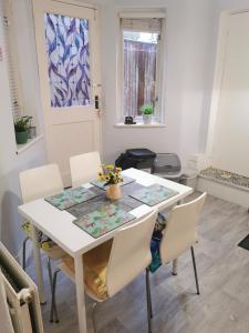 a white dining room table with white chairs at 1-Bed victorian gf Apartment in London in London