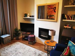 a living room with a fireplace and a blue couch at 1-Bed victorian gf Apartment in London in London