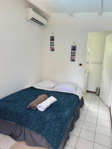 a bedroom with a bed with towels on it at PAVILLON CARAIBE in Petit-Bourg