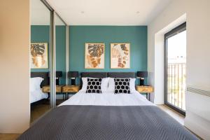 1 dormitorio con 1 cama grande y paredes azules en Staines Riverside by Charles Hope en Staines