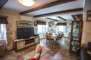 a living room with a television and a dining room at DIANA MORE in Baška