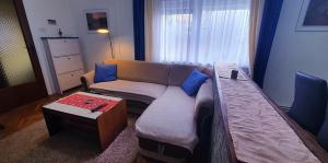 Apartman Ksenija في دياكوفو: غرفة معيشة مع أريكة وطاولة