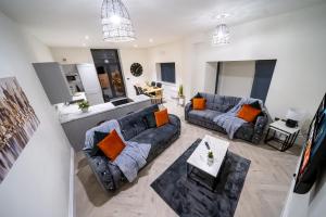 a living room with two couches and a kitchen at Modern 2-Bed Townhouse, Conveniently Located Near Leeds City Centre - Perfect for Corporate Stays in Farnley