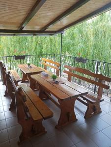 a group of wooden tables and benches on a patio at Casa Barry's in Tăşnad +11 photos