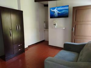 ein Wohnzimmer mit einem Sofa und einem TV an der Wand in der Unterkunft departamento en la mejor zona de cochabamba in Cochabamba