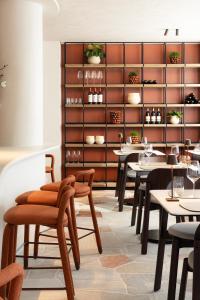 een restaurant met tafels en stoelen en een plank met wijnglazen bij Hotel du Bassin in Oostende