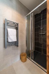 a bathroom with a shower with a towel and a basket at Bel appartement 6 personnes avec deux terrasses ensoleillées au coeur du village in Saint-Sorlin-dʼArves