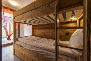 a couple of bunk beds in a room at Bel appartement 6 personnes avec deux terrasses ensoleillées au coeur du village in Saint-Sorlin-dʼArves
