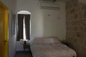 sypialnia z łóżkiem i oknem w obiekcie The stone house w mieście Kefar Daniyyel