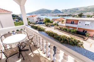 balcón con mesa, sillas y vistas a la ciudad en Apartments Ćurić, en Trogir