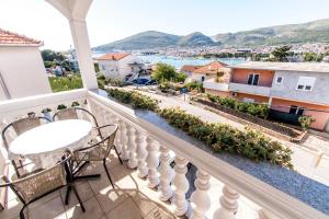 Un balcón con mesa y sillas y vista a una ciudad. en Apartments Ćurić, en Trogir