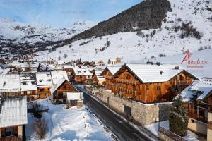 miasteczko ze śniegiem pokrytymi budynkami i górami w obiekcie Appartement Triplex 9 couchages avec terrasse au cœur du village w mieście Saint-Sorlin-dʼArves