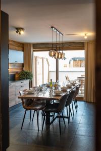 a dining room with a table and chairs and a kitchen at Appartement chaleureux 8 couchages avec terrasse au coeur du village in Saint-Sorlin-dʼArves +16 photos