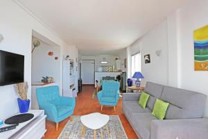 - un salon avec un canapé gris et des fauteuils bleus dans l'établissement B65 - Casa Le Ferreira in Praia da Luz, à Luz