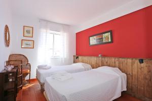- une chambre avec 2 lits et un mur rouge dans l'établissement B65 - Casa Le Ferreira in Praia da Luz, à Luz
