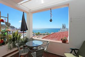 d'un balcon avec une table et des chaises et une vue sur l'océan. dans l'établissement B65 - Casa Le Ferreira in Praia da Luz, à Luz