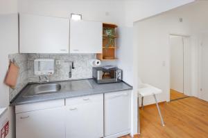 a small kitchen with white cabinets and a sink at ruhrApartments #Nähe A40 #zentral #fastWIFI #perfekt für Familien und Geschäftsreisen in Bochum