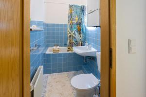 a blue tiled bathroom with a toilet and a sink at ruhrApartments #Nähe A40 #zentral #fastWIFI #perfekt für Familien und Geschäftsreisen in Bochum