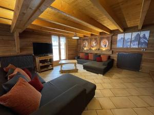 a living room with couches and a flat screen tv at Chalet montagnard 15 personnes - proche du centre du village in Saint-Sorlin-dʼArves