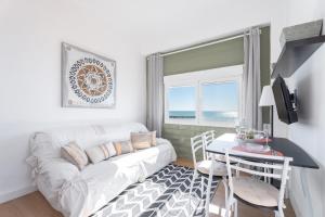 Una sala de estar con un sofá blanco y una mesa. en Casacamer S, en Sagunto