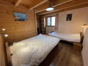 a bedroom with two beds in a log cabin at Chalet montagnard 15 personnes - proche du centre du village in Saint-Sorlin-dʼArves