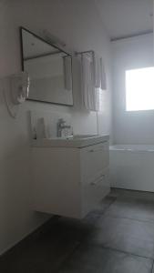a white bathroom with a sink and a mirror at Paradisier in Villars-les-Dombes